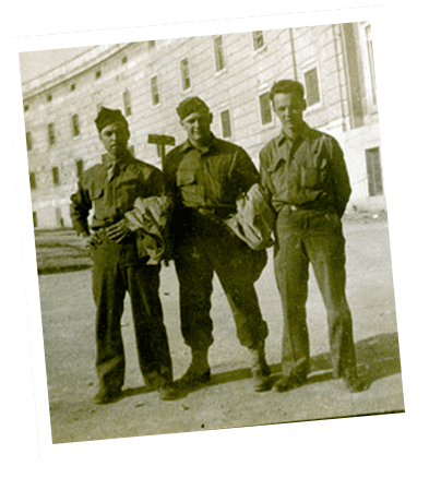 Three uniformed soldiers standing in front of building