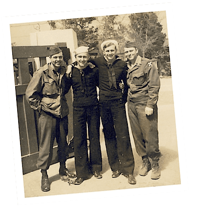 Four uniformed servicemen smiling in vintage photo