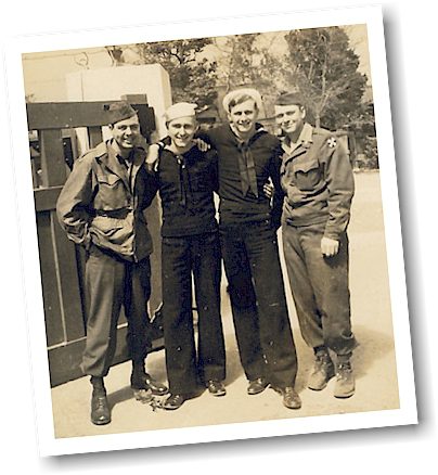 Four vintage servicemen posing together outdoors