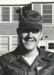 Smiling man in military uniform outside building