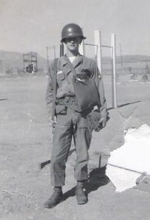 Soldier in helmet and uniform standing outdoors