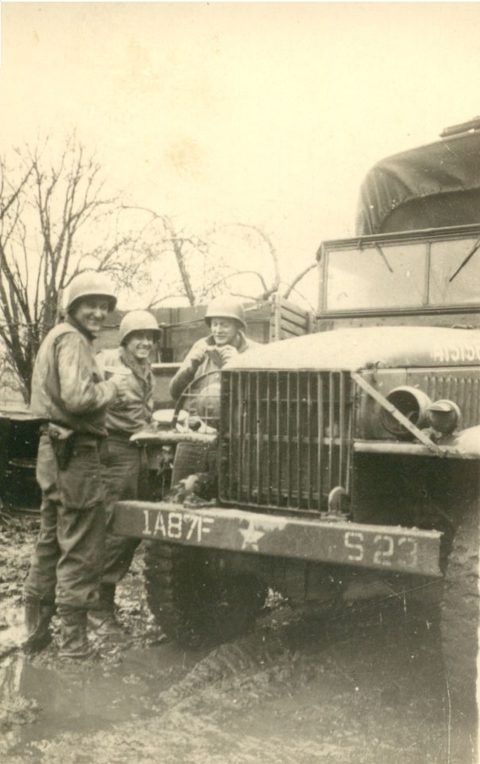 World War II soldiers beside military truck